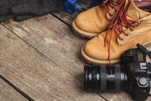 Close up photo of travel equipment for hiking trip on wooden background Chaussure